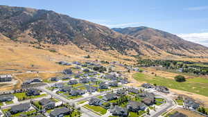 Aerial view of property and surrounding area with nearby suburban area and a mountainous background