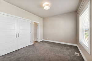Unfurnished bedroom featuring carpet flooring and a closet