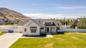 Modern inspired farmhouse featuring board and batten siding, a mountain view, and a shingled roof