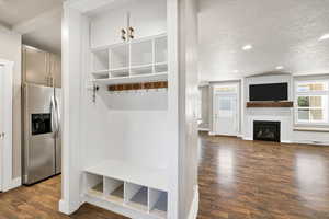 Mudroom with a textured ceiling, dark wood finished floors, recessed lighting, and a fireplace