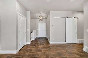Foyer entrance with a barn door and wood finished floors