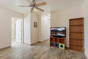 Living area with wood finished floors and ceiling fan