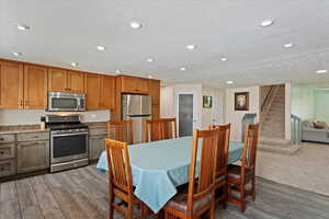 Dining area with stairs, wood finished floors, recessed lighting, and a textured ceiling