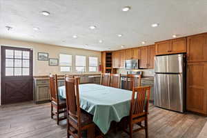 Dining space featuring light wood-style flooring, recessed lighting, and a textured ceiling