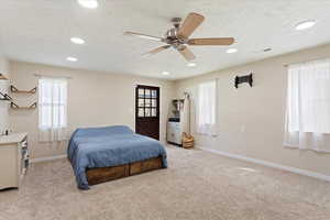 Bedroom with light colored carpet, a textured ceiling, ceiling fan, and recessed lighting