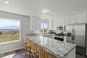 Kitchen with stainless steel appliances, slate flooring, white oak cabinets, granite countertops