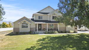 Traditional-style home featuring covered porch and brick siding