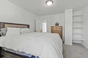 2nd floor bedroom with shelving and  a walk in closet