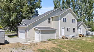 Back of house featuring entry steps, a shingled roof, and a garage