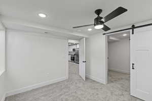 Basement bedroom with barn door dividing the room to create a separate area for a baby or study area. Also a walk in closet.