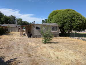 Rear view of house featuring a storage unit