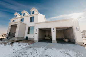 View of front of home featuring stucco siding and driveway