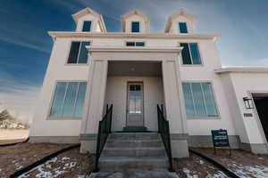View of front of home featuring brick siding and stucco siding