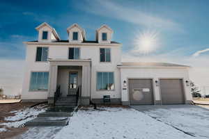 View of front of house featuring an attached garage and stucco siding
