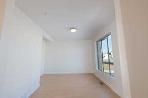 Empty room with baseboards and light wood-type flooring