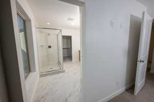 Full bath featuring a shower stall, light marble finish flooring, recessed lighting, and vanity