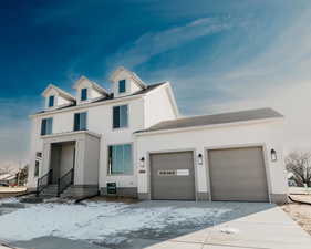 View of front of property with a garage, concrete driveway, a shingled roof, and stucco siding