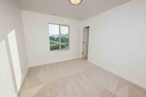 Carpeted empty room with baseboards