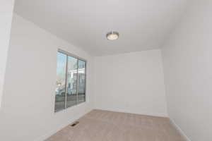 Unfurnished room with light colored carpet and baseboards