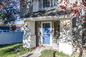 Doorway to property featuring stucco siding and roof with shingles