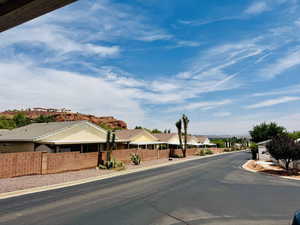 View of asphalt road featuring curbs and a residential view