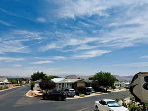 View of asphalt road with a residential view, curbs, and a mountain view