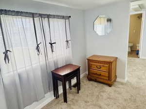 Living area featuring light colored carpet and baseboards