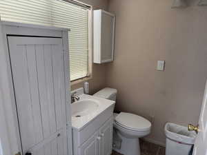 Half bathroom featuring a textured wall, vanity, and tile patterned flooring