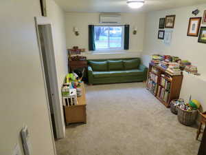 Sitting room featuring carpet and a wall mounted AC