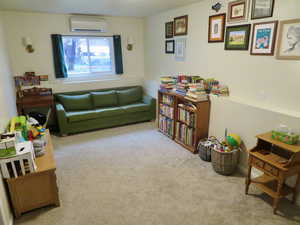 Living area with carpet and a wall unit AC