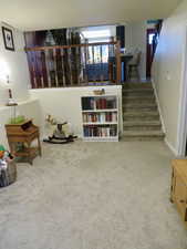Sitting room featuring carpet flooring and stairway
