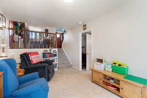 Living area with light carpet and stairs