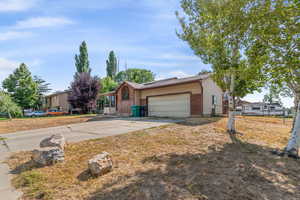 View of front of home with concrete driveway, a garage, and brick siding