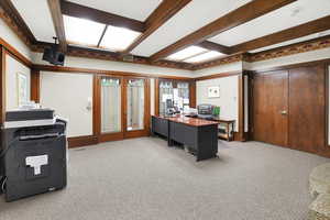 Office area featuring carpet floors, beamed ceiling, and french doors