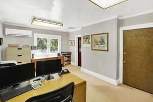 Office space featuring light colored carpet, a wall mounted AC, and ornamental molding