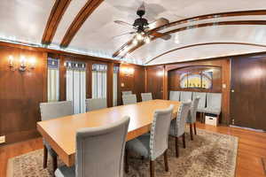 Dining room with wood finished floors, lofted ceiling, and a ceiling fan