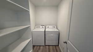 Washroom with dark wood-type flooring and washer and dryer