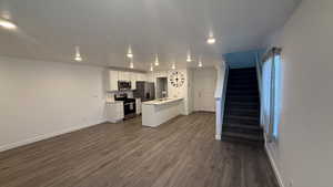 Kitchen featuring white cabinetry, light countertops, open floor plan, stainless steel appliances, and recessed lighting