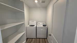 Laundry area featuring dark wood-type flooring and washer and dryer