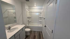 Full bathroom featuring dark wood-style flooring, washtub / shower combination, and vanity