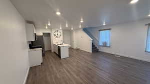 Kitchen featuring white cabinetry, dark wood-style floors, white range with gas stovetop, stainless steel dishwasher, and recessed lighting