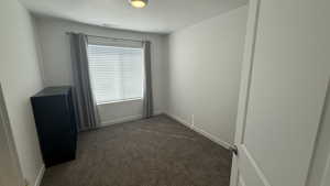 Spare room with dark colored carpet and a textured ceiling