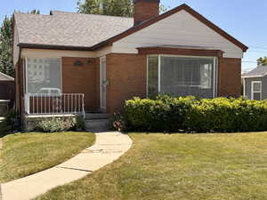 Front of house featuring, porch, brick siding, a brand new architectural roof, and large bay window