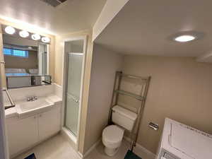 3/4 Bathroom with tiled shower, vanity, mirror and lighting