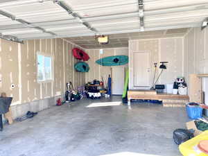 Garage featuring a garage door opener and tandem 3rd bay.
