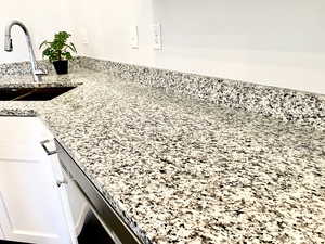Detailed view of white cabinets and granite stone counters throughout the home.