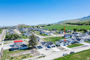 Aerial view of residential area featuring a mountainous background at road up to Cherry Peak Resort.