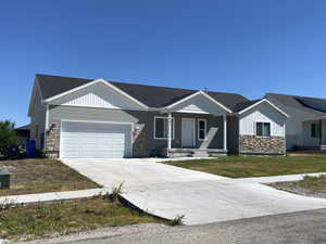 View of front of property featuring concrete driveway, stone siding, a garage, a porch, and a front lawn