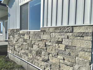 Exterior view of board and batten siding and stone siding
