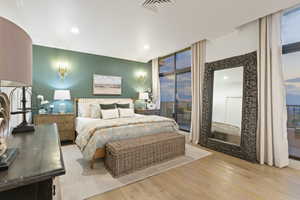 Bedroom featuring access to exterior, wood finished floors, ornamental molding, recessed lighting, and expansive windows